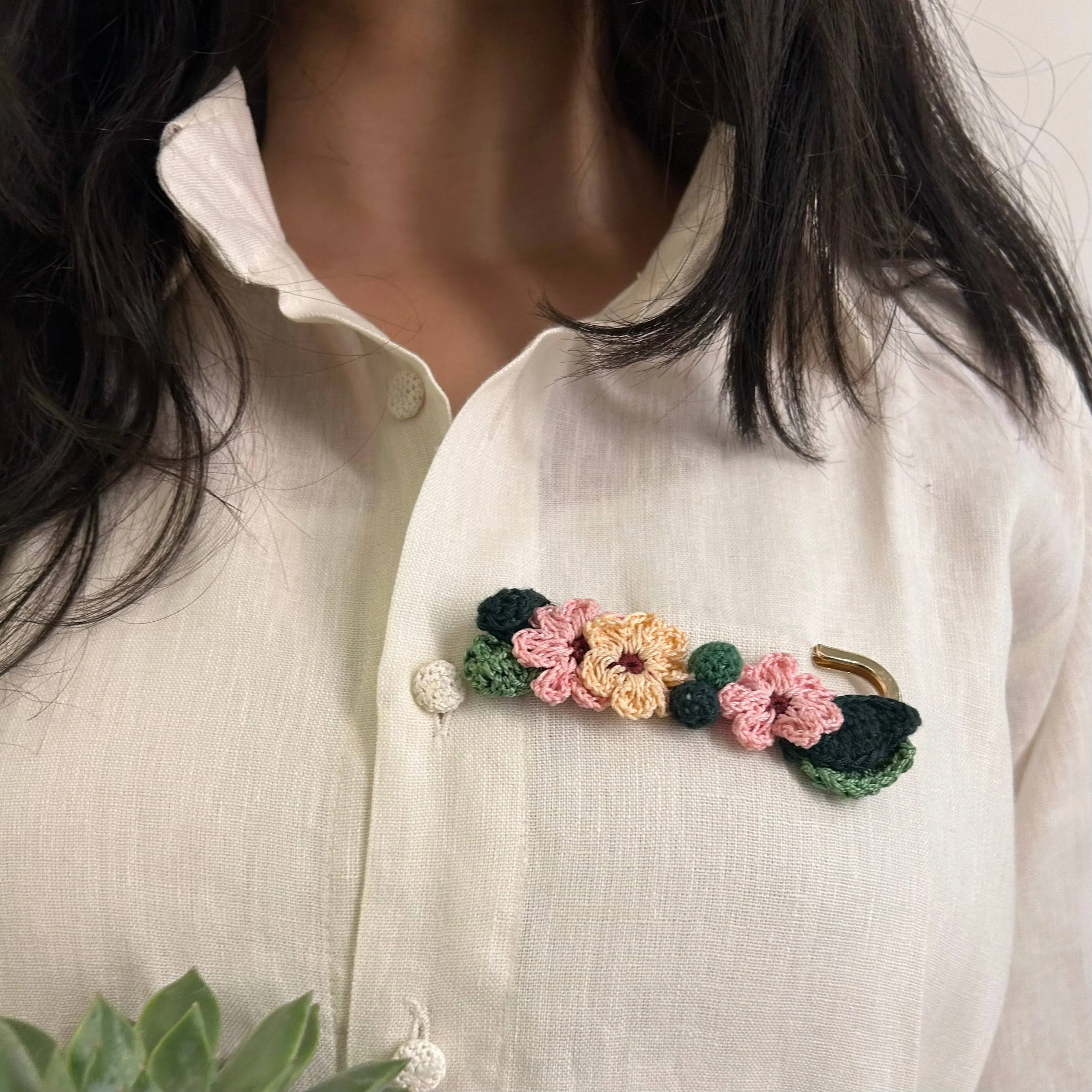 Pink and peach crochet brooch on a metal pin